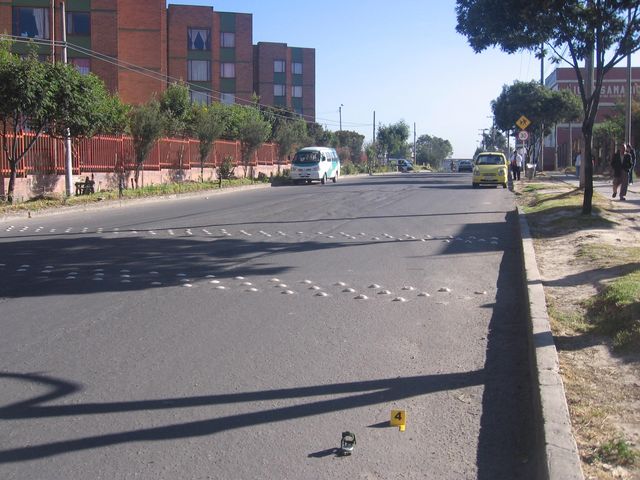 esta debe ser la primera fotografia al tomar cuando se esta realizando la fijacion del lugar de los hechos. observese el diseño de la via, en aparencia no presenta tanta inclinacion respecto al sentido de la imagen.